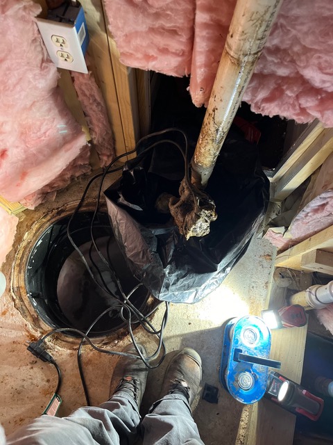 Sump pump basin in a crawl space being serviced by BF Plumbing & Drain
