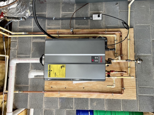 Rinnai tankless water heater installed on a basement wall with copper supply lines